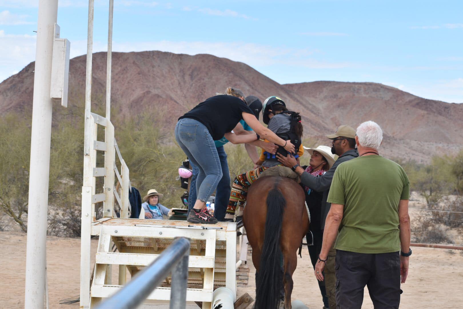 Assisting Jaqueline in mounting a horse